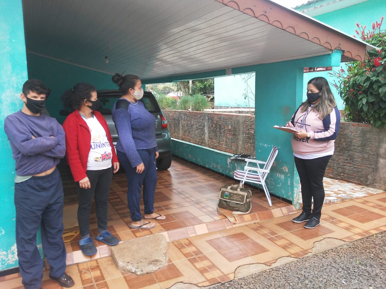 Agente comunit&aacute;ria entrevista uma fam&iacute;lia sobre mercado e consumo